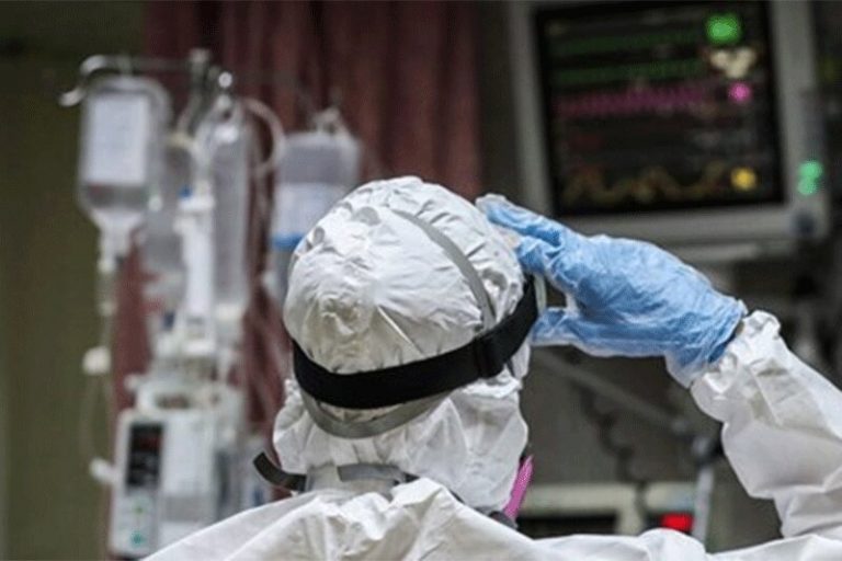 عکس| تصویری تکان دهنده از پرستاری که با سرم به دست به حال بیماران رسیدگی میکند